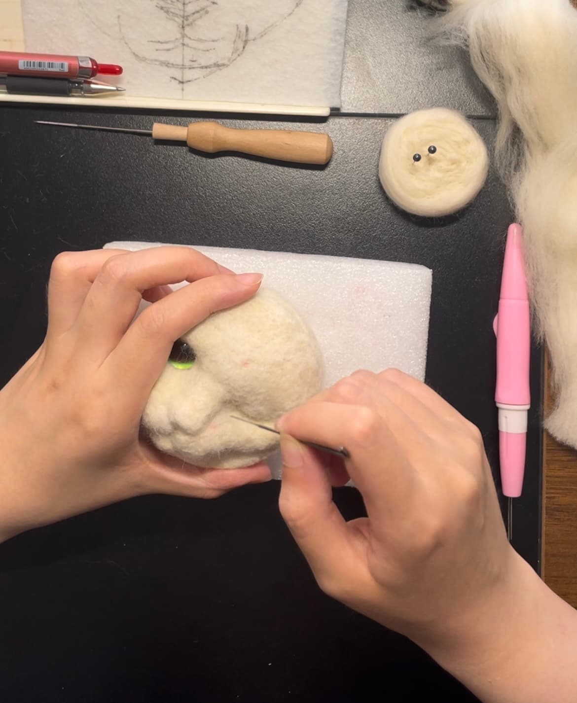 The process of me creating a customized needle felted cat